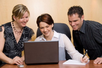 Three people looking at laptop